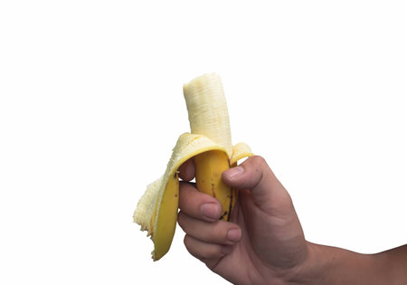 A banana in his hand on a white background.の写真素材