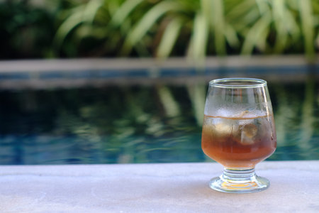 glass of ice tea beside the poolの写真素材