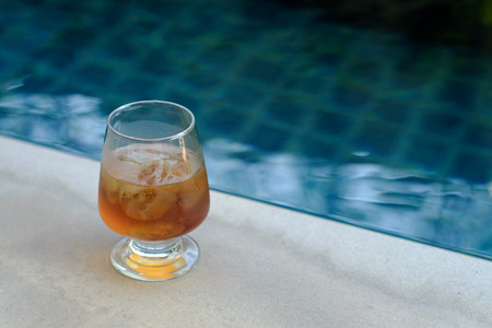 glass of ice tea beside the poolの写真素材