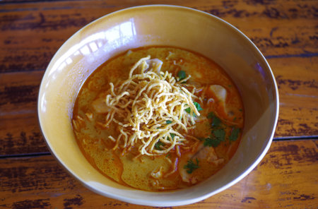 NNorthern Thai Noodle Curry Soup in bowl put on the wooden table