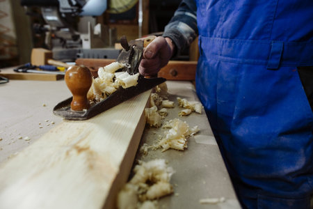 woodworker keeps in the hands of the plane,  stands on a timber bar and is ready for work...