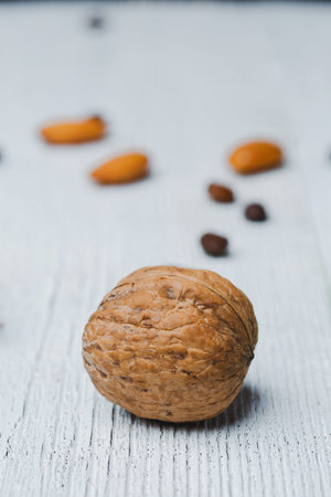 Walnut lie on an old wooden white table,  with cracked paint on the surface. raw food diet concept....