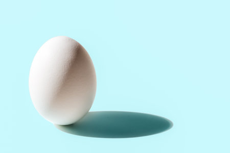 White egg with shade on blue background, isometric compositionの写真素材