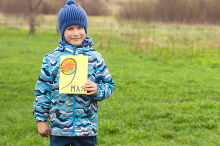 Greating card for the may 9 Victory Day . Childrens creativity. Boy demonstrates handmade card.