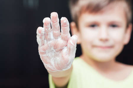 Front view on boys hand with soap foam, focus on hand, personal hygiene concept, copyspaceの写真素材