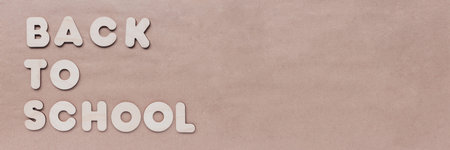 Inscription BACK TO SCHOOL of wooden letters on craft background. The concept of the importance of...