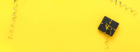 Christmas gift box on yellow background on yellow background, long bannerの写真素材