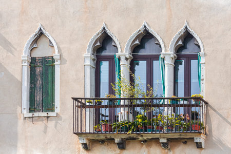 Facade of venetian houses with typical old venetian windows on it. Sunny day. Venice, Italyの写真素材