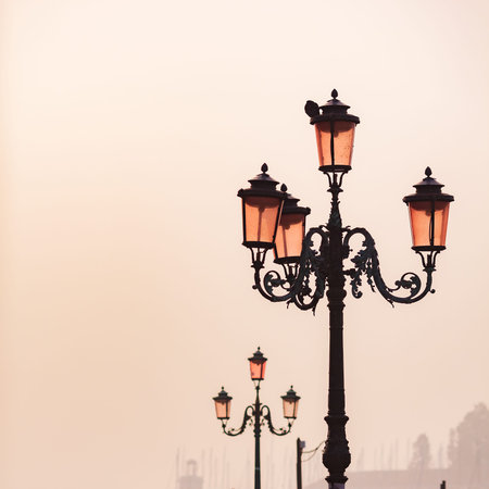 Old lanterns on the San Marco square at sunrise in Venice , Italy