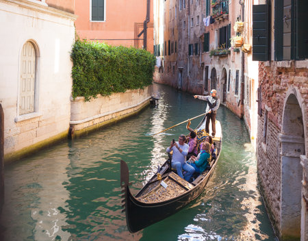 VENICE, ITALY - OCTOBER, 07 2017 Tourists travel on gondola on small canal. Gondola trip is the most popular touristic activity in Veniceのeditorial素材