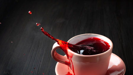 Cup of tea with splash on wooden backgroundの写真素材