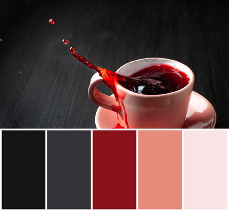 Color matching palette and cup of tea with splash on wooden backgroundの写真素材