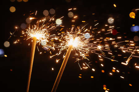 Bright glittering burning sparkler on dark backgroundの写真素材