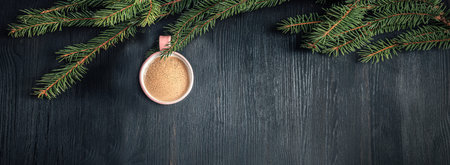 Christmas toy made from fragrant cup of coffee and hang on pine branch. Holiday concept on dark wooden backgroundの写真素材