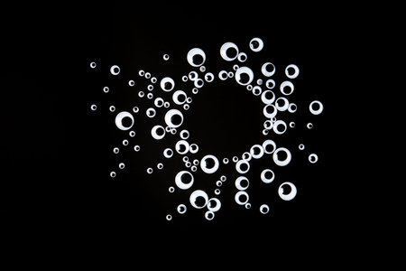 Googly eyes plastic toys laying on black background with copyspaceの写真素材