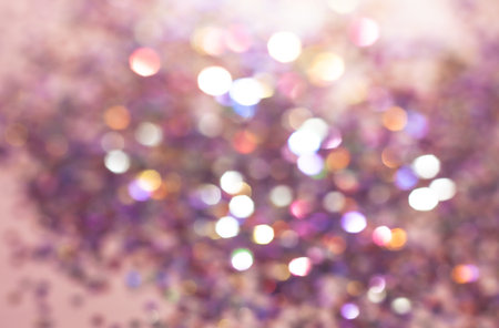 Defocused confetti with bokeh lights, abstract background. Blurred beautiful shiny Christmas lights toned pink colorの写真素材