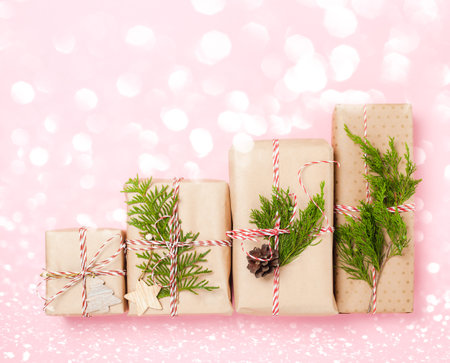 Preparing for the Christmas holidays. Some wrapped gifts on pink paper background