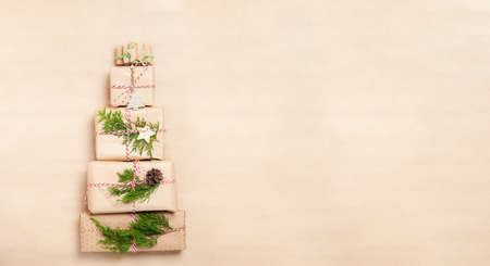 Preparing for the Christmas holidays. Concept of Christmas tree made from wrapped gifts on craft paper backgroundの写真素材