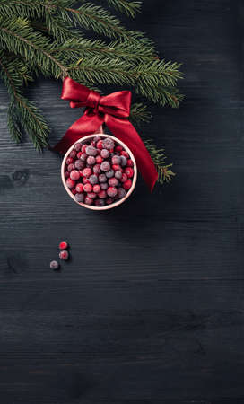 Close up of frozen cranberries as Christmas bauble on dark wooden backgroundの写真素材