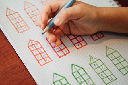 Close up view from above to schoolboy study math and doing developing creative exercisesの写真素材