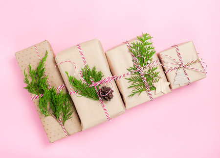 Preparing for the Christmas holidays. Some wrapped gifts on pink paper background