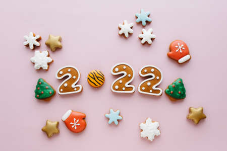 Gingerbread numbers 2022 lying on pink background. Top view. New Year greeting cardの写真素材