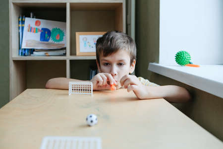 The child plays table football on the desk. Speech therapy game for the development of breathingの写真素材