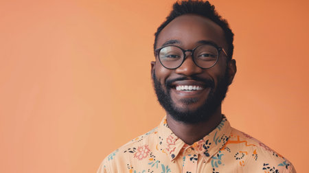 Portrait of smiling black american african man wear glasses  isolated on peach backgroundの素材