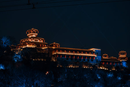 Historic Zhiyindian architecture in Wuhan China shining with lanterns under dark sky.