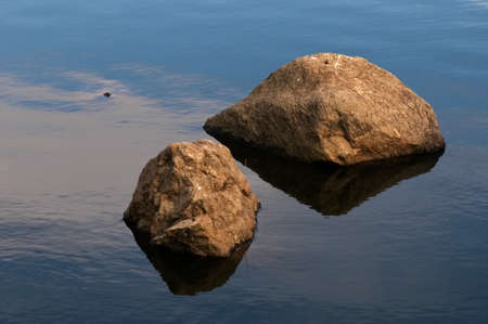 stones and their reflections in the waterの写真素材