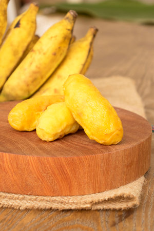 Fried banana fritters on chopping boardの写真素材