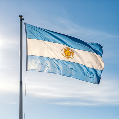 Argentina flag waving in the wind against a blue sky.の素材