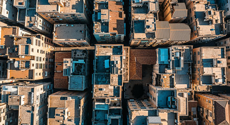 An overhead drone shot captures the intricate rooftop landscape of a dense city, bathed in warm, late-afternoon sunlight, revealing geometric patterns and architectural details.の素材