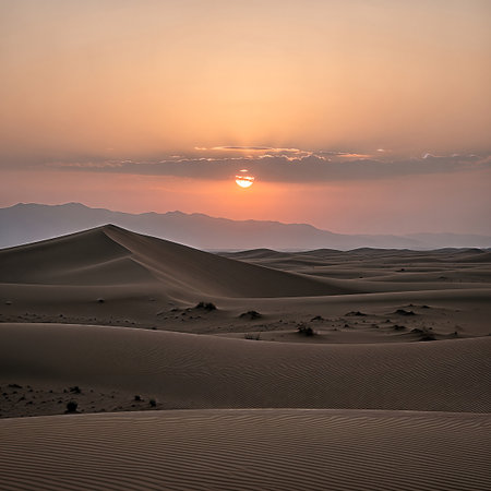 Vast desert landscape with undulating sand dunes bathed in the warm, soft glow of a setting sun, creating a tranquil and majestic scene.の素材