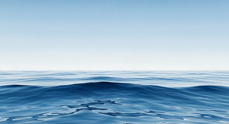 Calm ocean view with gentle waves under a pale blue sky. The water reflects light, creating patterns. Peaceful and tranquil seascape.の素材