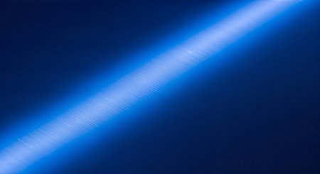 A glowing blue light streaking across a dark blue backgroundの素材