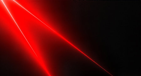 Bright red laser beams shining in a dark room or space with a black backgroundの素材