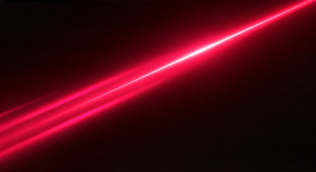 A bright red laser light beam shines diagonally across a dark backgroundの素材