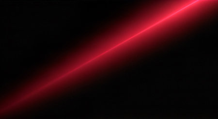 A bright red light beam shining diagonally across a dark backgroundの素材