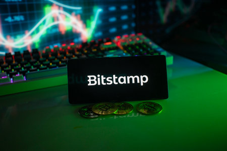 Dhaka, Bangladesh 18 September 2025:Bitstamp logo in a dim setting with coins and a vivid chartのeditorial素材