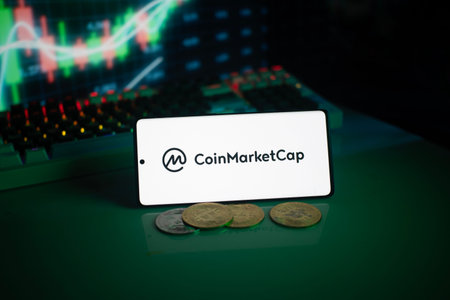 Dhaka, Bangladesh 18 September 2025:CoinMarketCap logo with coins and a glowing chart in a dim...