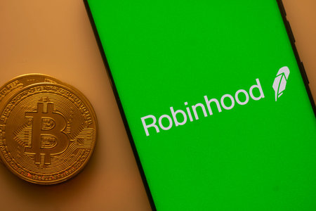 Dhaka, Bangladesh 22 September 2025:Green Robinhood screen with Bitcoin coin, representing...