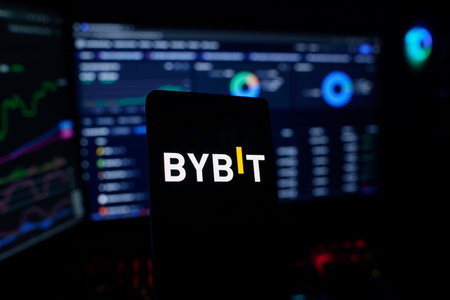 Dhaka, Bangladesh 26 September 2025:Smartphone with BYBIT logo in front of trading charts on screens
