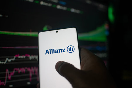 Dhaka, Bangladesh 20 Feb 2026:Hand holding phone displaying Allianz logo against stock chart...