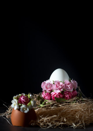 Easter egg with pink flowers on a black background with copy spaceの写真素材