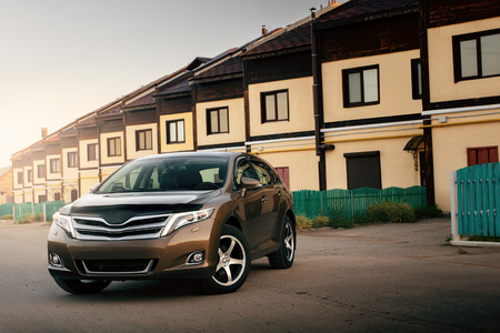 Car stay near houses during sunsetのeditorial素材