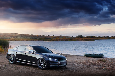 car and boat on coast near riverのeditorial素材