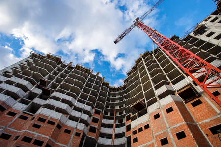 Crane construction bricks concrete building in cityの写真素材