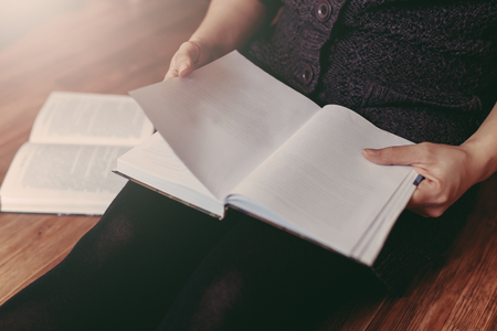 Woman reading a few books on the floorの写真素材