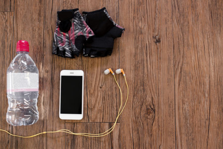 Fitness equipment accesories on wooden background, view above